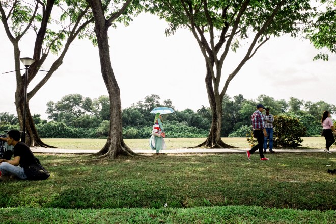 A lady in green with a blue umbrella (Photo by Ng Shi Wen)