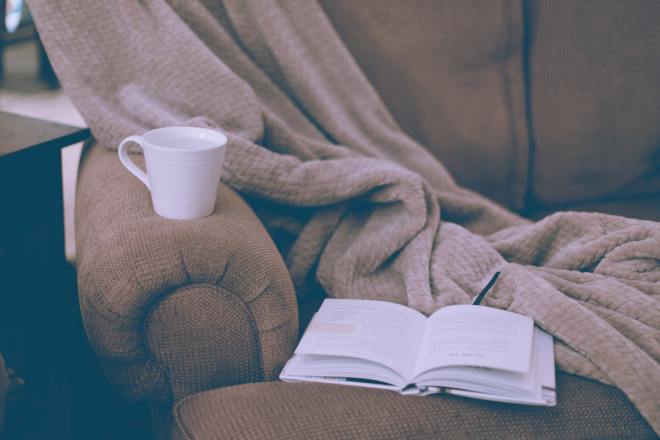 Relaxing at home with a book and coffee (Photo by Sixteen Miles Out on Unsplash)