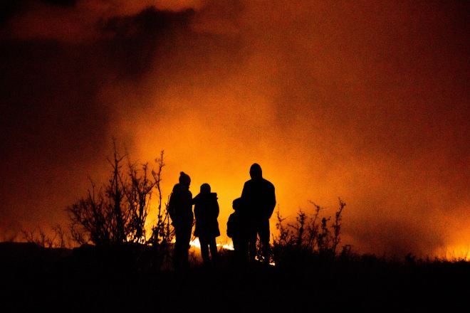 Family watching a wildfire in the distance (Photo by Caleb Cook on Unsplash)