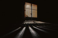 Dark prison-like gate (Photo by Ayrus Hill on Unsplash)